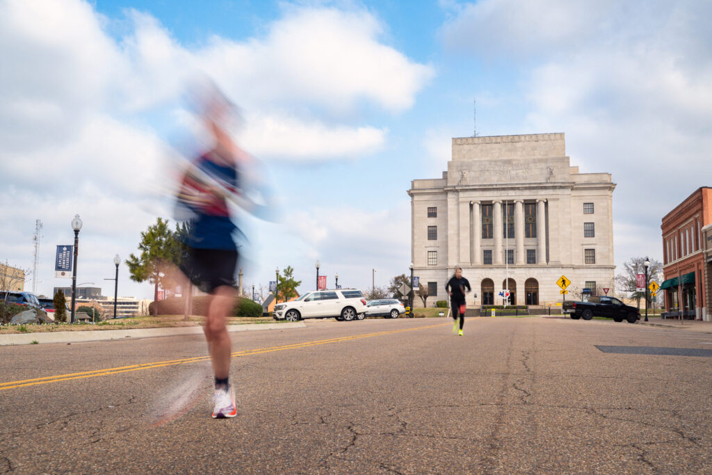 A runner passes in front of the U.S. Post Office and Courthouse on the Arkansas–Texas state line during the Run the Line Half Marathon in Texarkana.