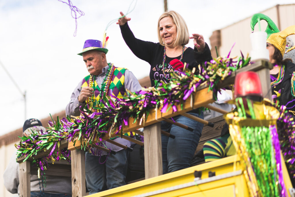 People throwing beads from a Mardi Gras parade float in downtown Texarkana