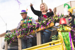 People throwing beads from a Mardi Gras parade float in downtown Texarkana