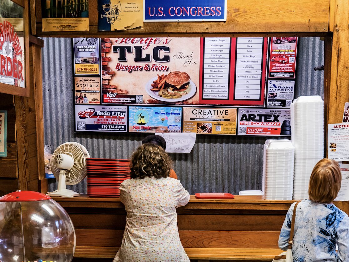 People ordering food at the counter at George’s TLC Burgers & Fries in Texarkana.