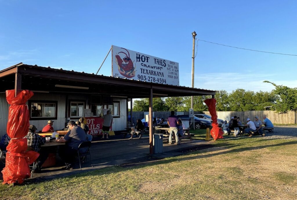 Hot Tails Crawfish & Seafood in Texarkana with outdoor picnic tables and crawfish boil diners.